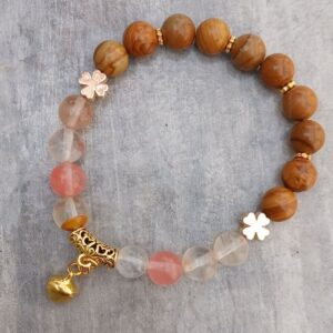 Bracelet élastique en jaspe bois et fluorite – création unique. Perles de 8 mm, finitions dorées, pendentif clochette. Taille : 16-17 cm.
