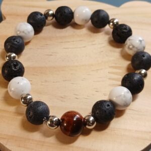 Bracelet élastique 17/18 cm mêlant pierre de lave, howlite blanche et œil de tigre rouge, rehaussé de séparateurs argentés. Un bijou élégant et chargé d’énergie.