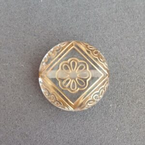 Perle en acrylique ronde , diamètre 22 mm. Couleur : translucide - impression reliefs dorés.  Perforée : 2 trous. 