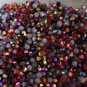 Collection Tiny Trésor Rubis est un mélange de perles toupies en verre à facettes de 4mm. Vendue par lot de 30 gr. Couleurs : reflets dorés, mauve, rouge